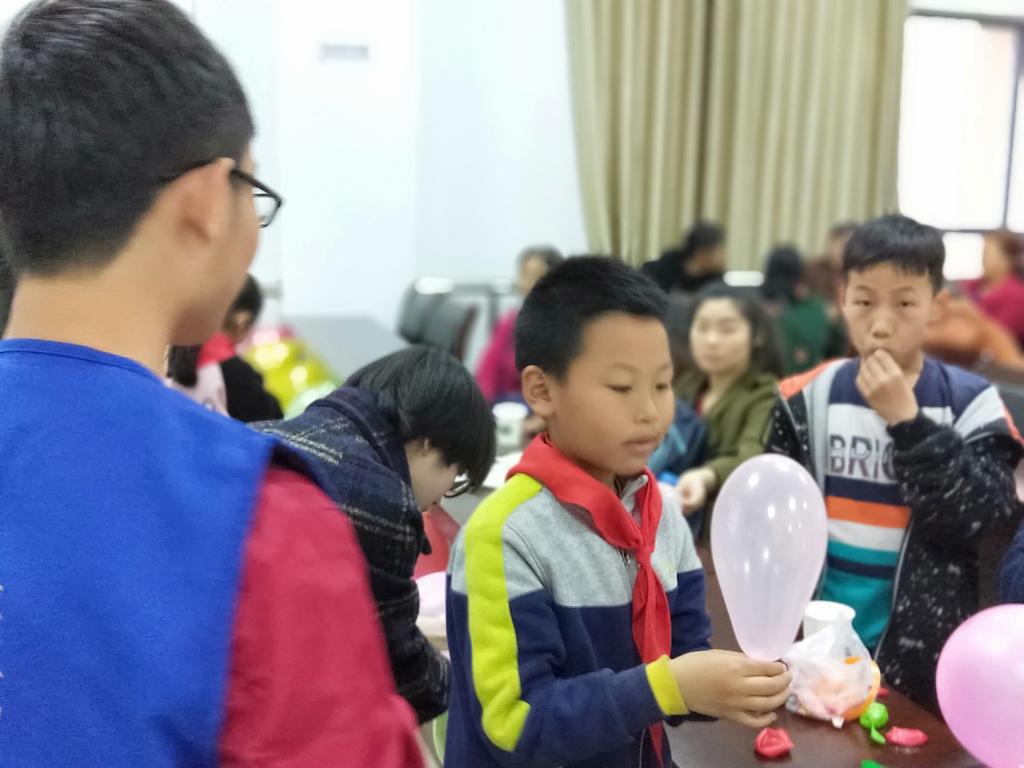 志愿者与小朋友一起布置活动场? vsbhref=